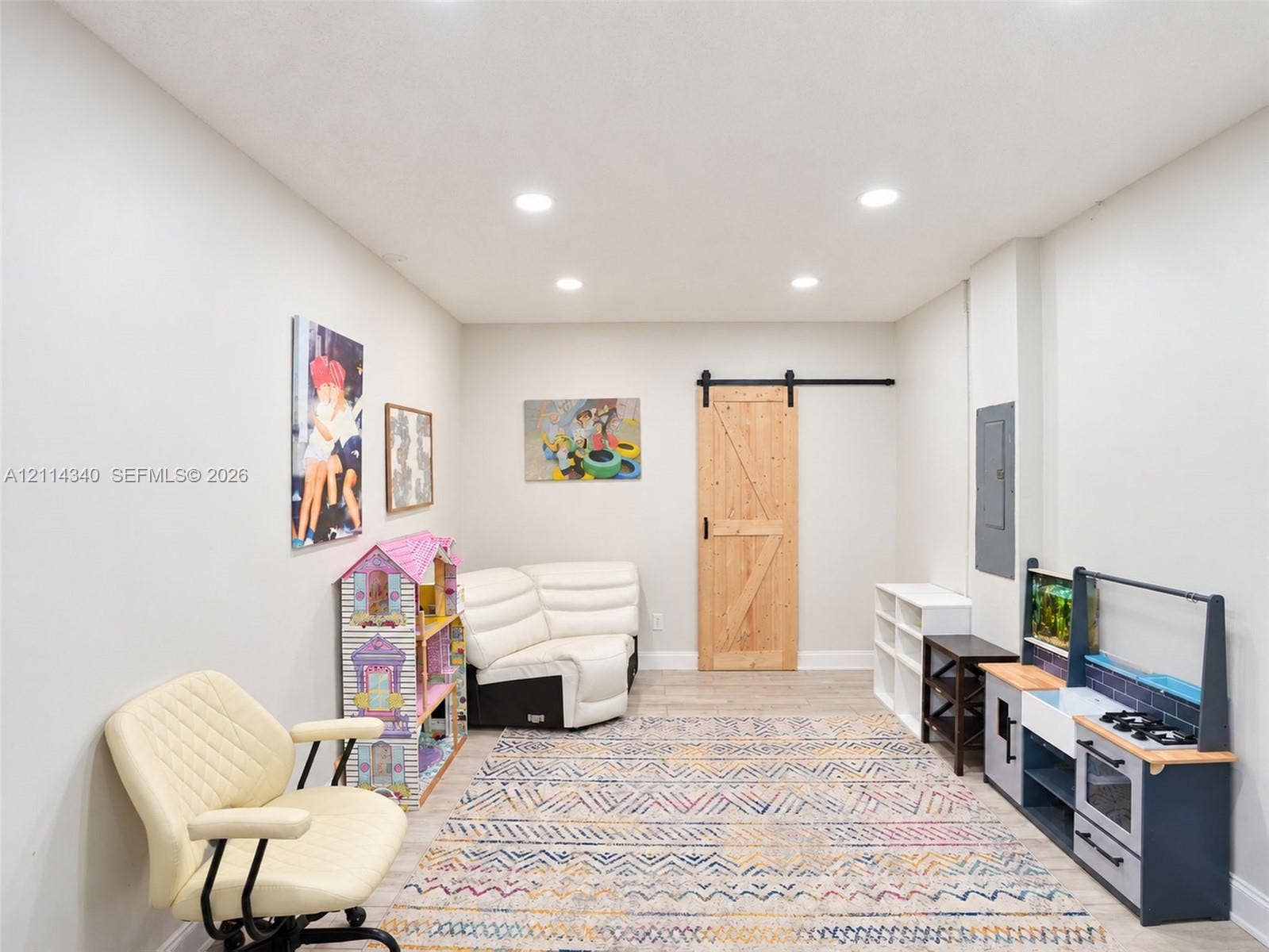 3586 SW 50th Street, Hollywood, FL 33312 Interior room featuring wood-finish flooring, recessed lighting, and a sliding wood barn-style door with matte black hardware