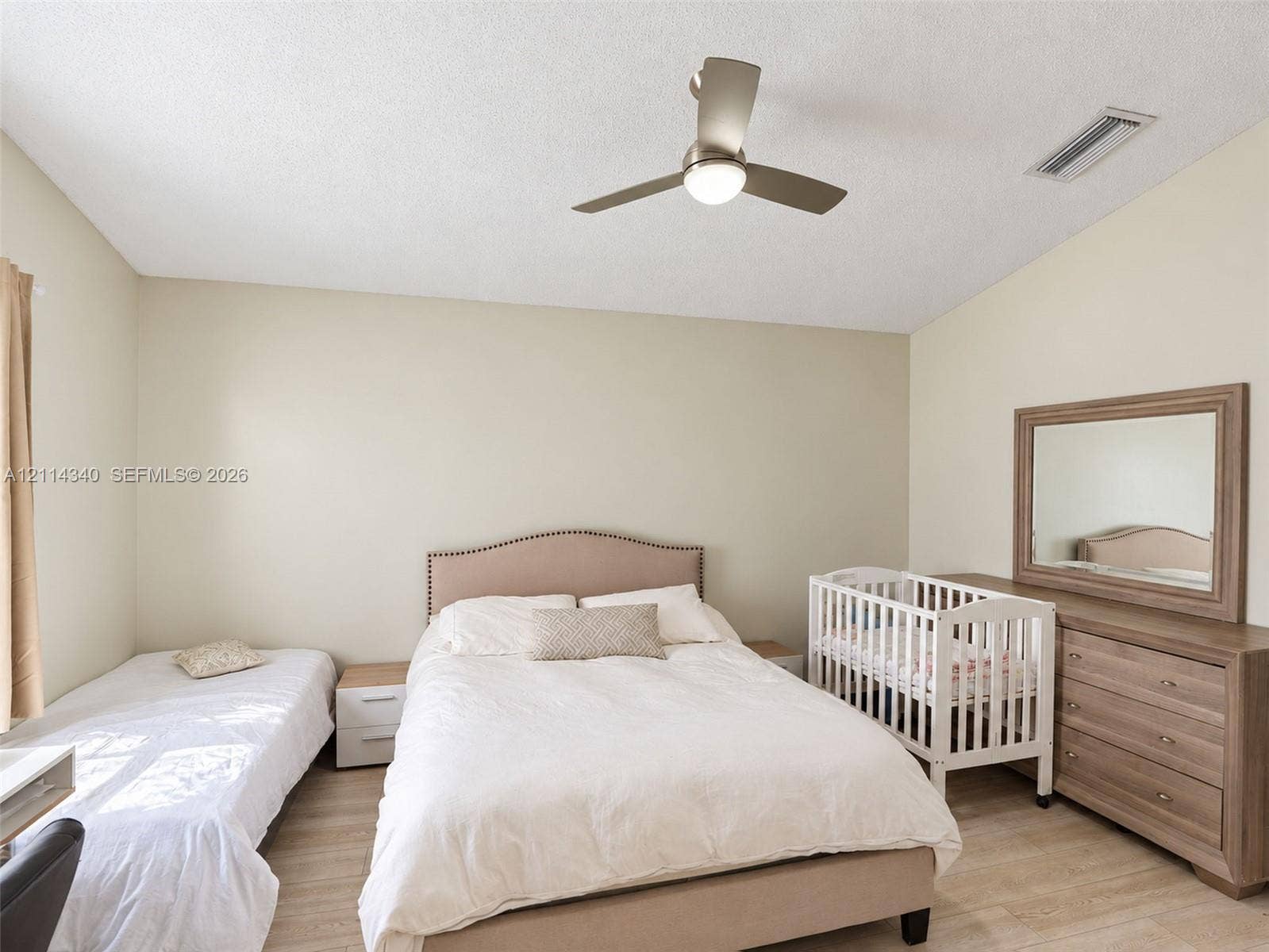 3586 SW 50th Street, Hollywood, FL 33312 Vaulted ceilings, neutral wall tones, wood-finish flooring, and a modern brushed-nickel ceiling fan with integrated lighting