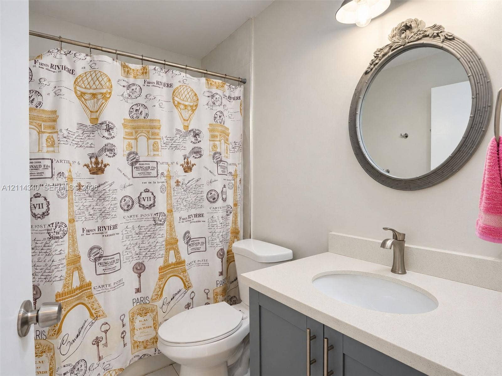 3586 SW 50th Street, Hollywood, FL 33312 Bathroom featuring a vanity with shaker-style cabinetry, light-toned countertop, integrated oval sink, brushed-finish faucet, and an ornate circular wall mirror