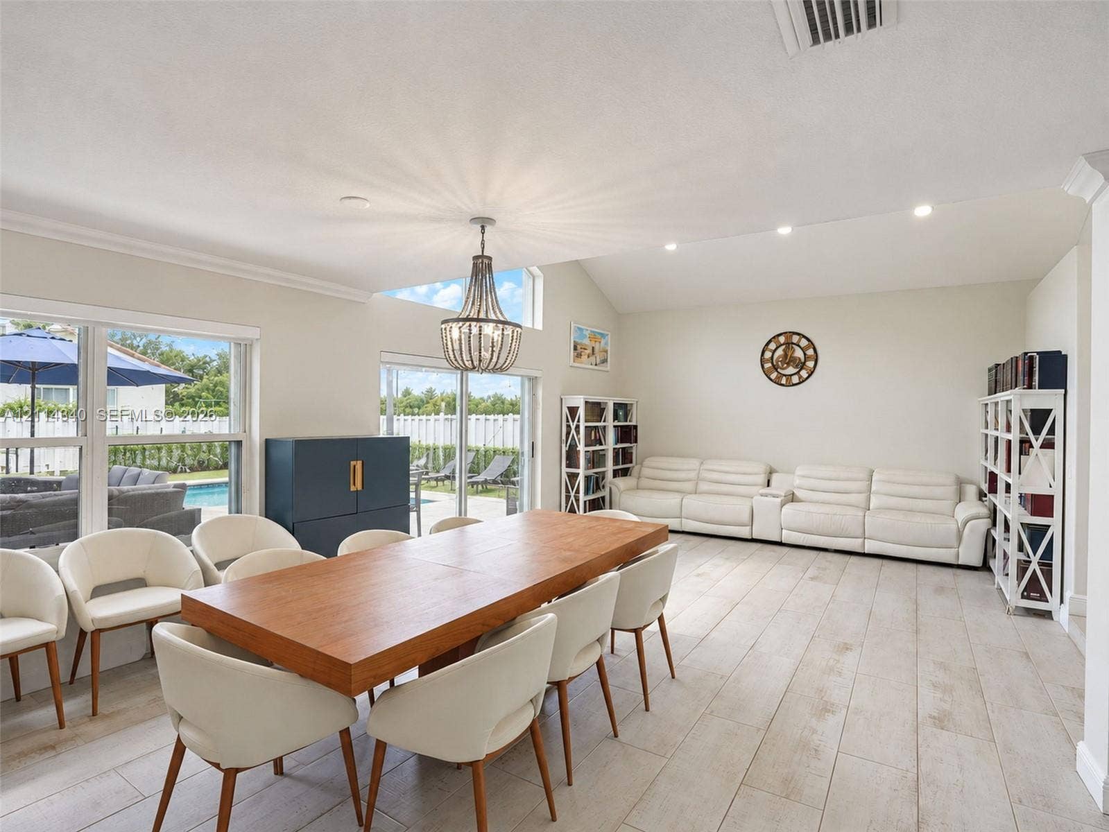 3586 SW 50th Street, Hollywood, FL 33312 Vaulted ceilings with recessed lighting, wood-finish tile flooring, a statement chandelier, and large sliding glass doors providing natural light