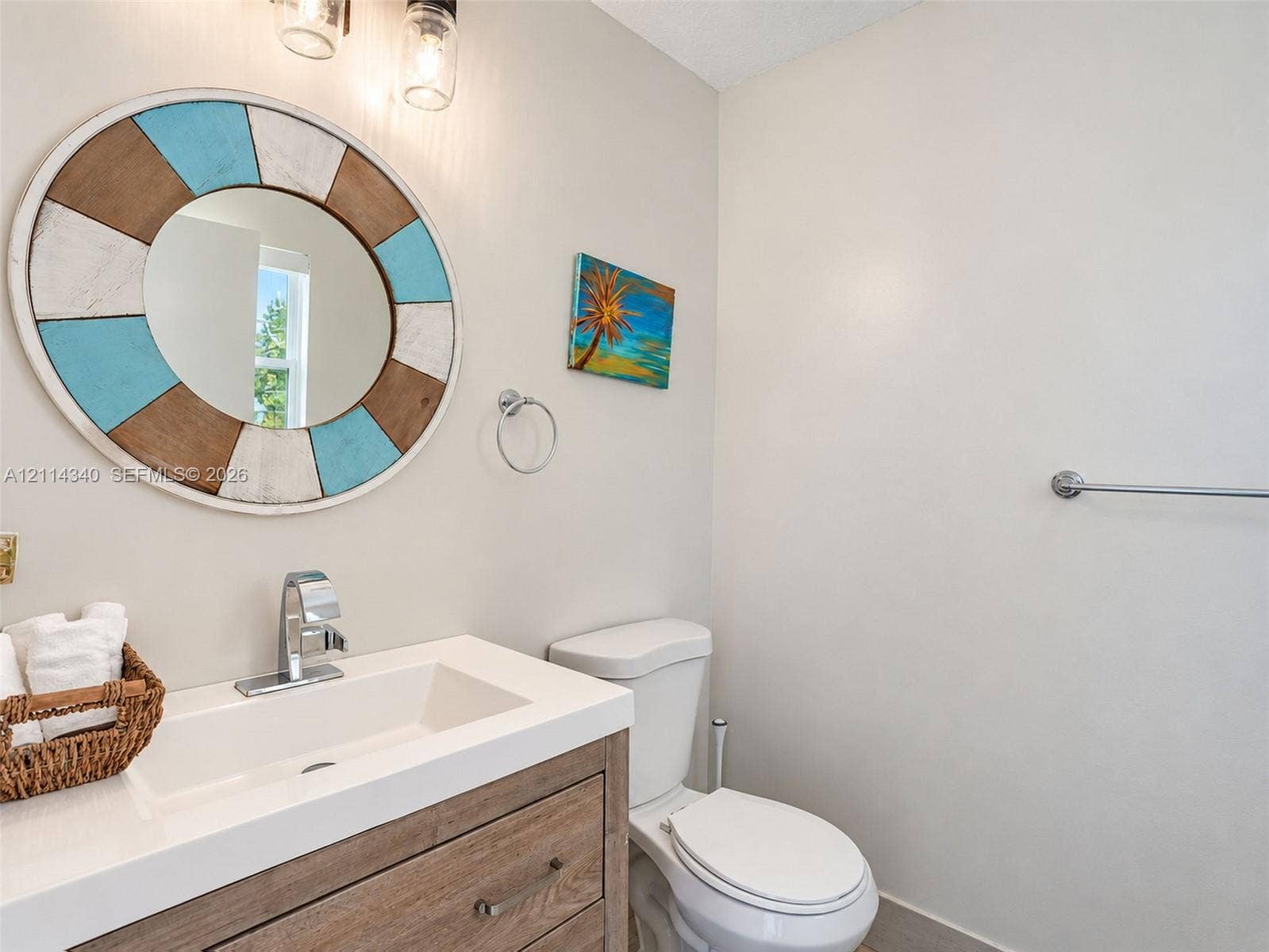 3586 SW 50th Street, Hollywood, FL 33312 Wood-finish vanity cabinet with a white countertop and integrated sink, polished chrome faucet, and dual wall-mounted pendant light fixtures