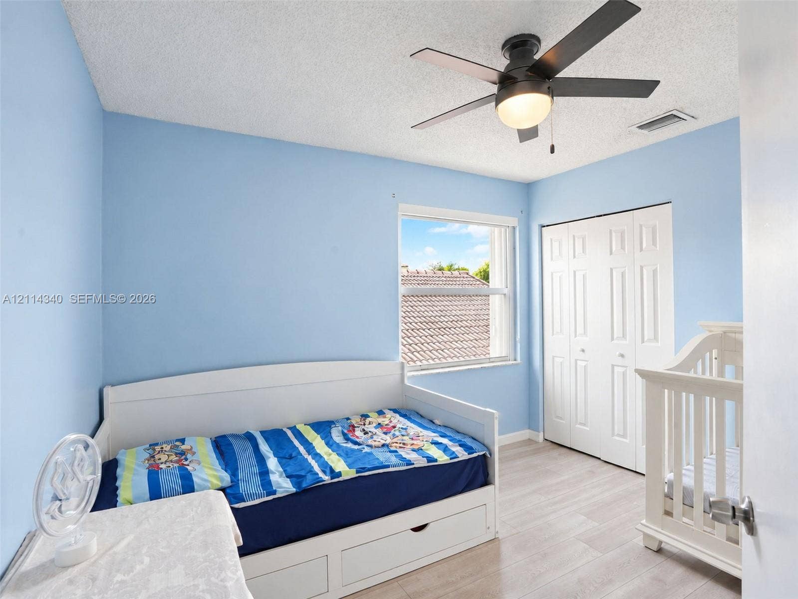 3586 SW 50th Street, Hollywood, FL 33312 Room featuring wood-finish flooring, a multi-panel bi-fold closet, a ceiling fan with integrated light fixture, and a single-hung window