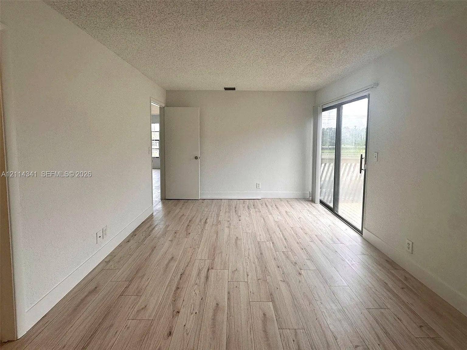 Interior space featuring wood-finish flooring, sliding glass door, and neutral wall tones