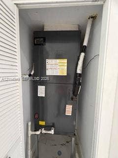 Vertical HVAC air handler unit enclosed within a closet featuring louvered bi-fold doors