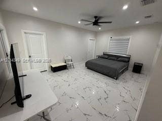 Spacious room featuring light-toned large-format tile flooring with veining, recessed lighting, a modern ceiling fan, and paneled doors
