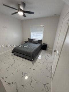 Large-format stone-style tile flooring, ceiling fan with integrated lighting, and window with built-in blind