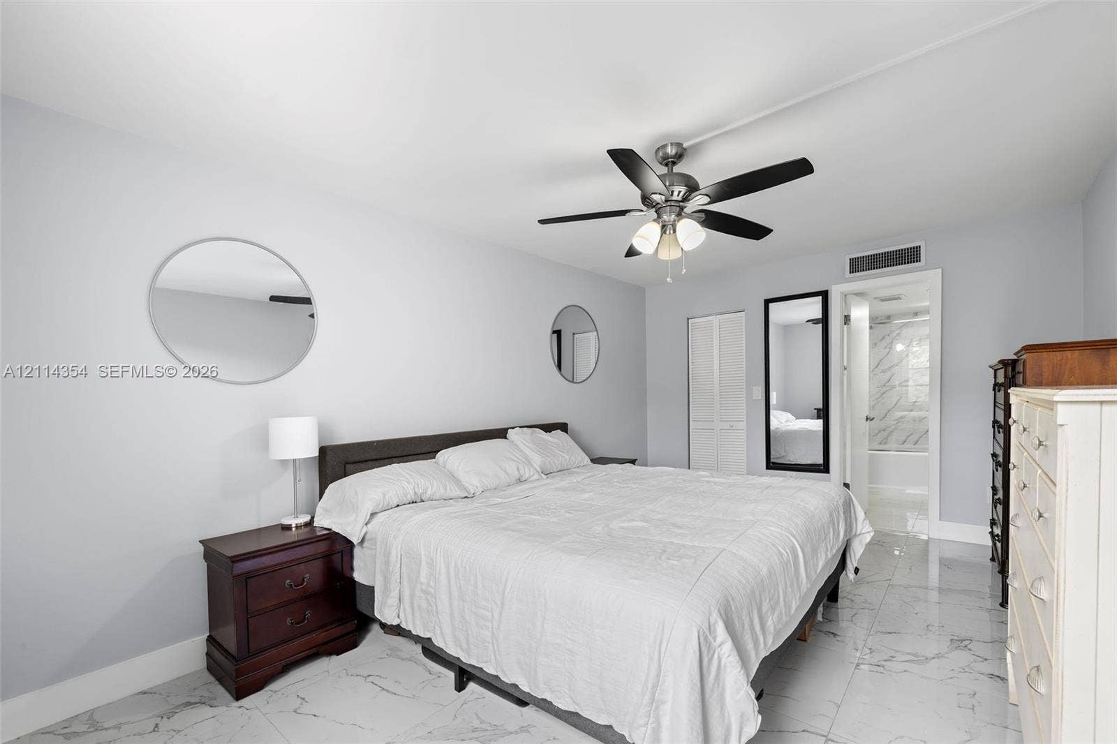 14401 SW 88th Street, #410N, Miami, FL 33186 Neutral-toned interior featuring polished stone-finish flooring, a multi-blade ceiling fan with integrated lighting, and a closet with bifold doors