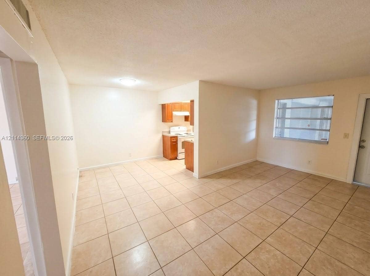 Neutral-toned ceramic tile flooring, built-in wooden cabinetry, recessed lighting, and multi-pane horizontal window