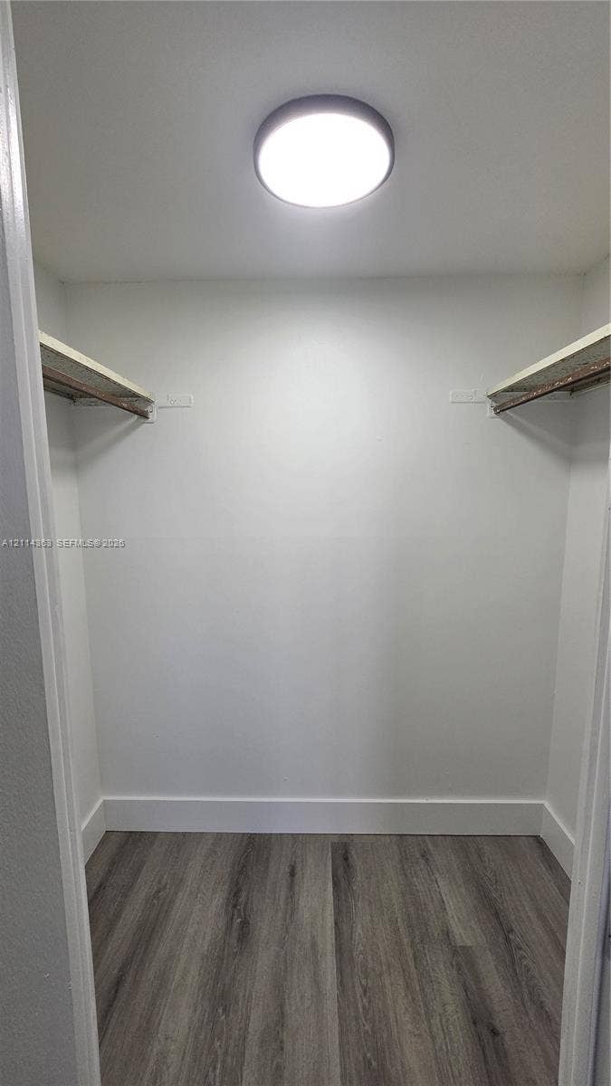 14840 Naranja Lakes Boulevard, #1G, Homestead, FL 33032 Storage space featuring wood-finish flooring, two fixed shelving units with integrated clothing rods, and a ceiling-mounted flush light fixture