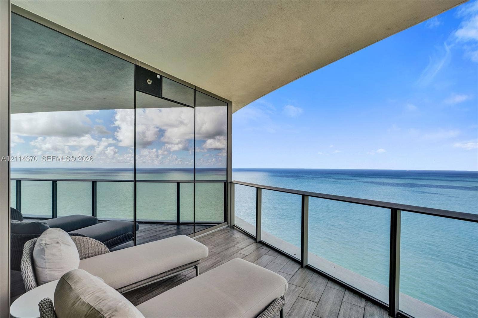 Sunny Isles Beach, Sunny Isles Beach, FL 33160 Covered private balcony featuring tile flooring, floor-to-ceiling glass paneling, and metal railing overlooking the ocean