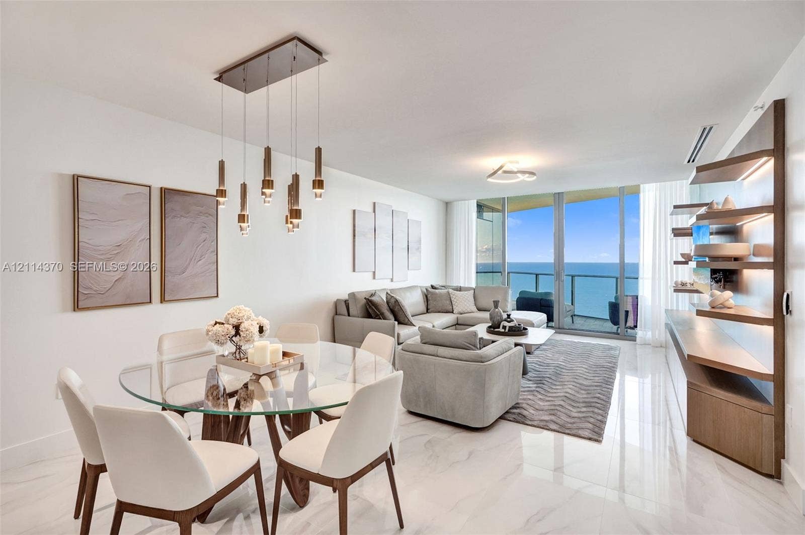Sunny Isles Beach, Sunny Isles Beach, FL 33160 Polished stone flooring throughout, floor-to-ceiling glass panel doors, custom built-in wooden shelving with integrated lighting, and a multi-pendant rectangular light fixture