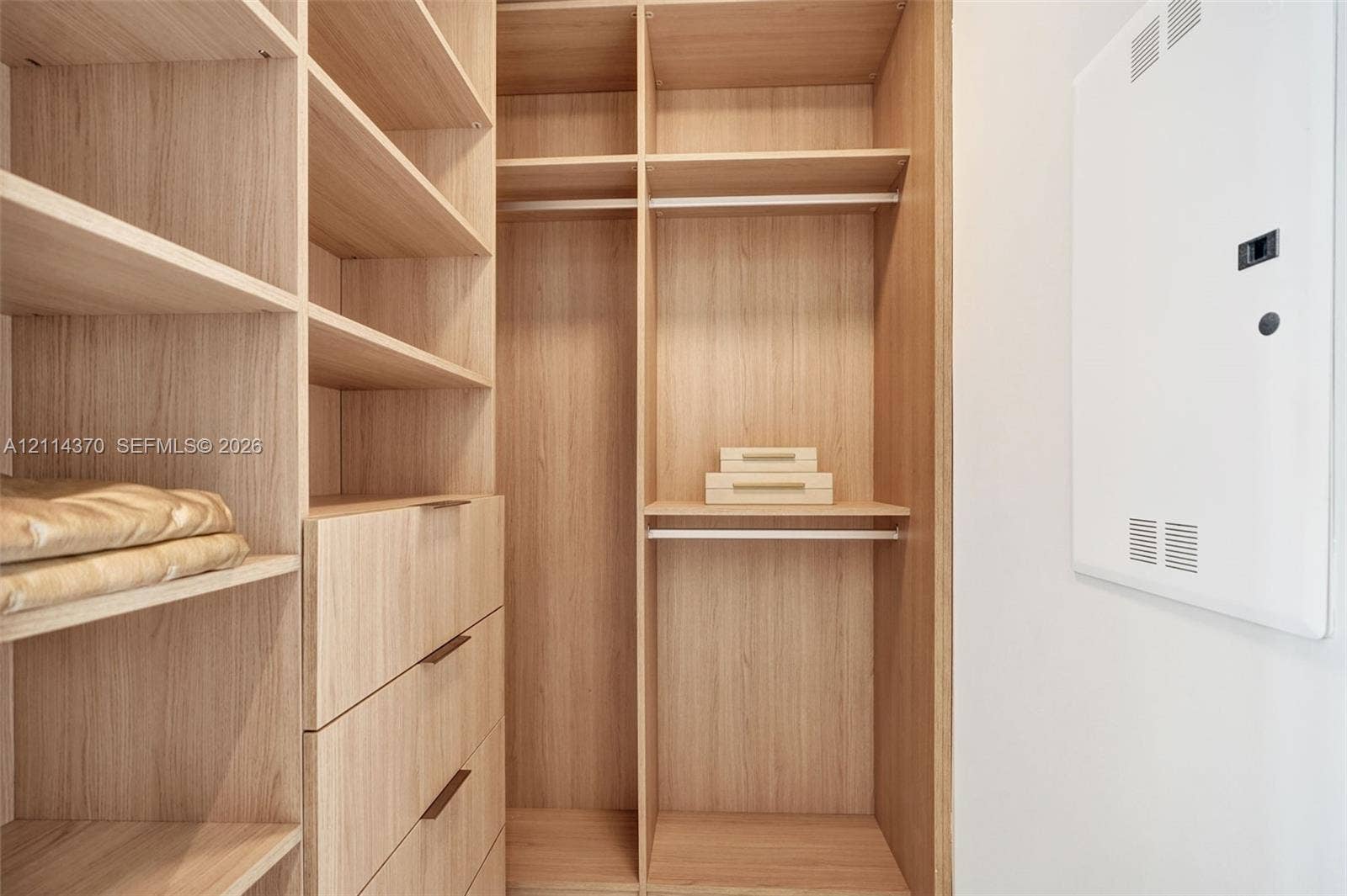 Sunny Isles Beach, Sunny Isles Beach, FL 33160 Built-in wood-finish cabinetry featuring open shelving, integrated hanging rods, and four pull-out drawers with slender hardware