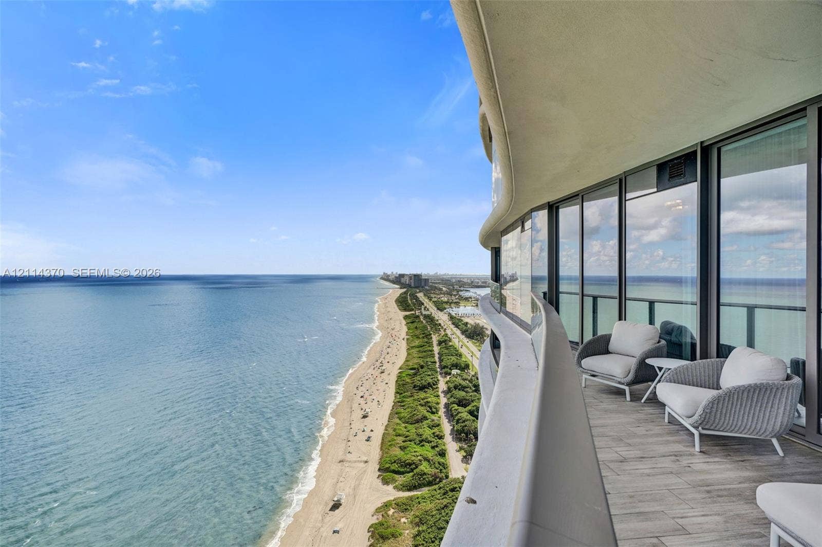 Sunny Isles Beach, Sunny Isles Beach, FL 33160 Curved wrap-around balcony with wood-finish tile flooring and floor-to-ceiling glass paneling