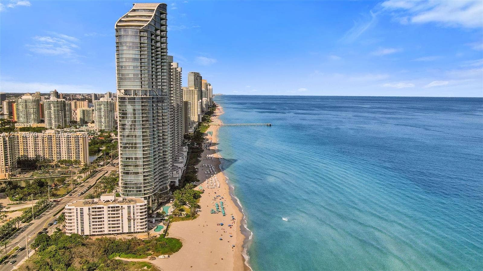 Sunny Isles Beach, Sunny Isles Beach, FL 33160 High-rise residential tower featuring glass facade construction, direct oceanfront location, and expansive shoreline access