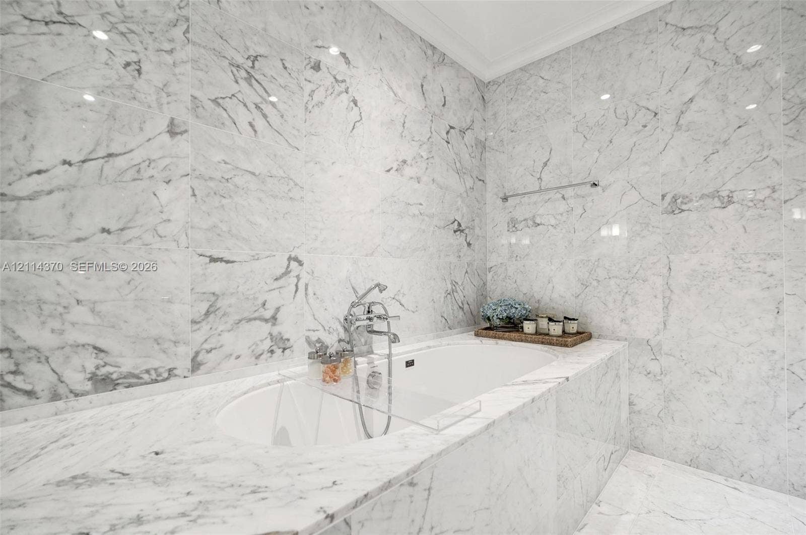 Sunny Isles Beach, Sunny Isles Beach, FL 33160 Soaking tub enveloped in floor-to-ceiling stone tile with matching surround and polished metal wall-mounted faucet