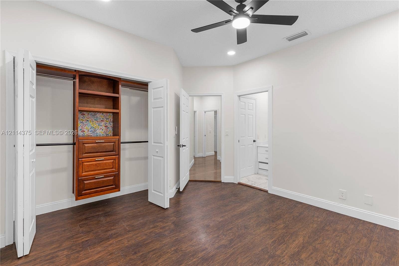 1206 S Manor Drive S, Weston, Weston, FL 33326 Wood-finish flooring, closet with built-in wooden cabinetry, multi-panel doors, and a ceiling fan with integrated lighting