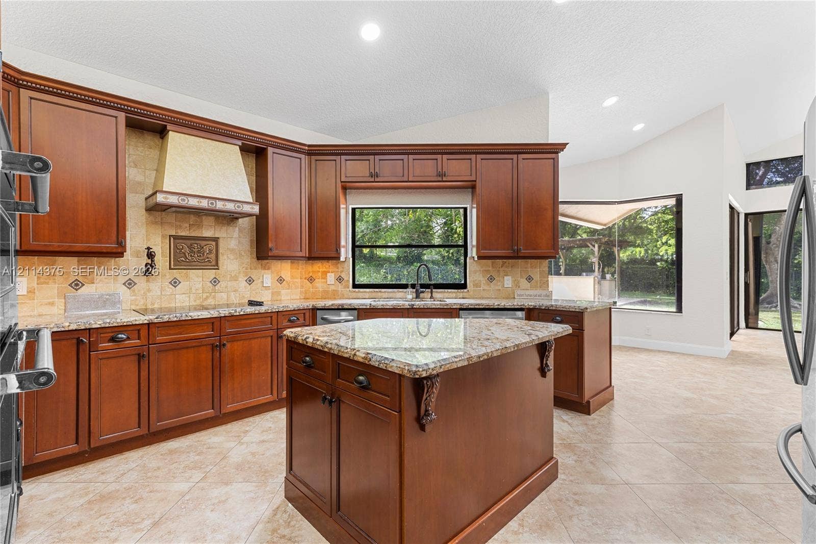 1206 S Manor Drive S, Weston, Weston, FL 33326 Kitchen featuring stained wood cabinetry, stone countertops, a center island with corbel detailing, a tiled backsplash, and recessed lighting
