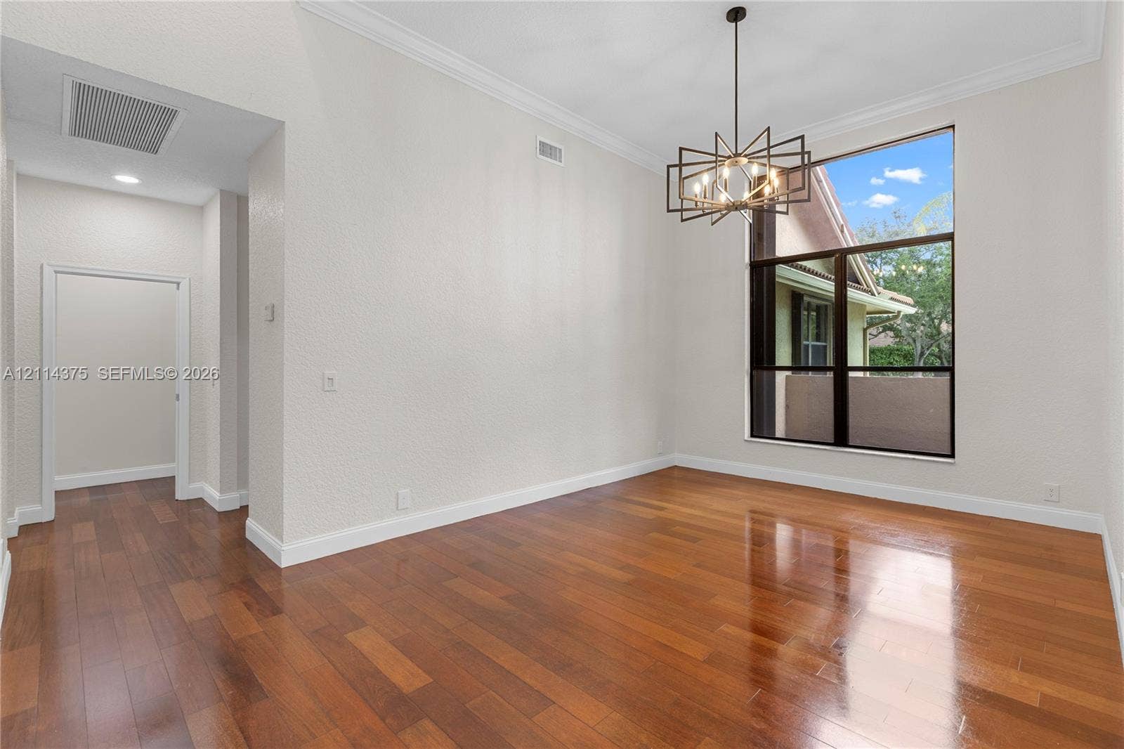 1206 S Manor Drive S, Weston, Weston, FL 33326 High-ceiling room featuring wood-finish flooring, a contemporary multi-arm metal chandelier, crown molding, and a large multi-pane window