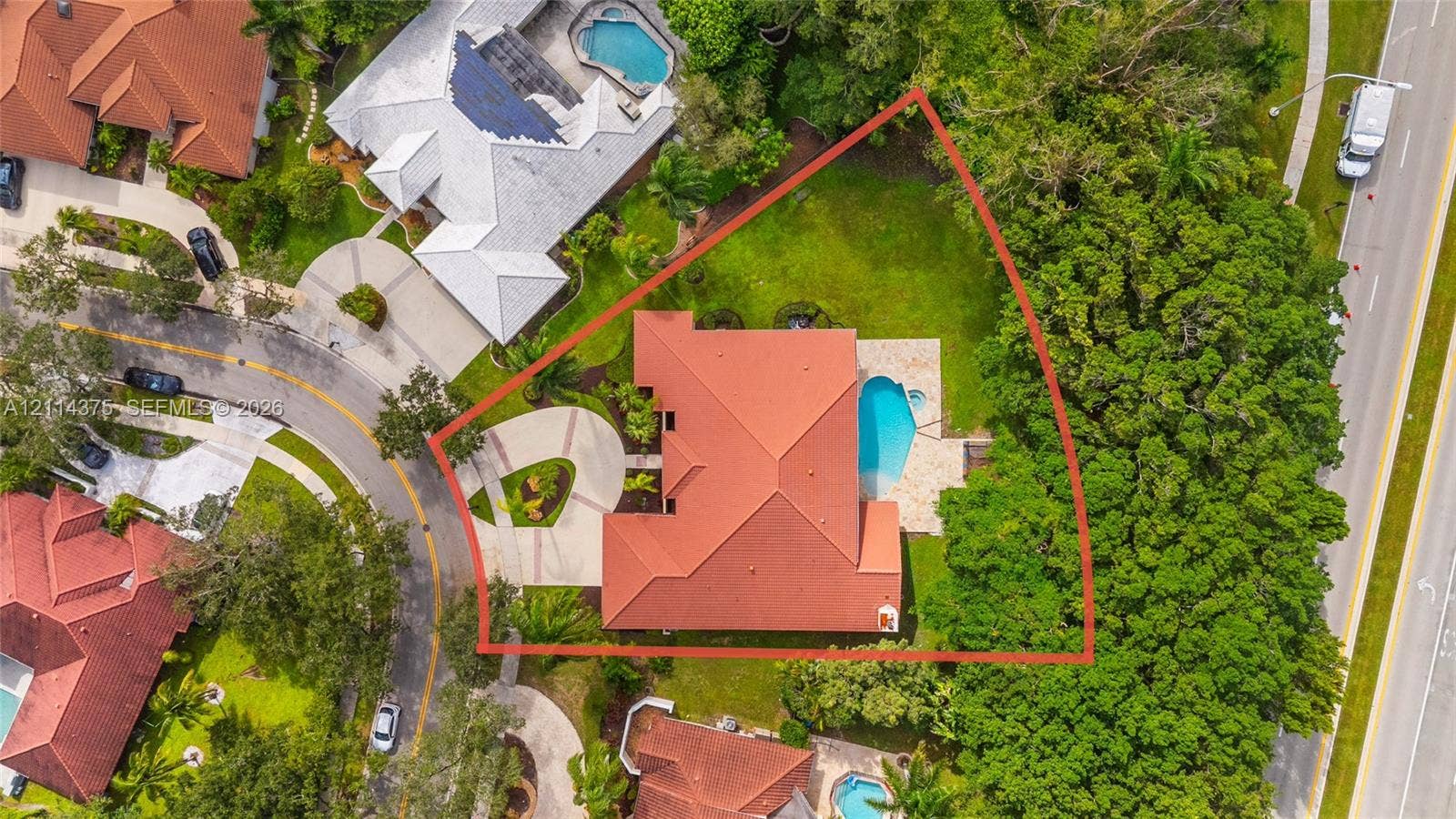 1206 S Manor Drive S, Weston, Weston, FL 33326 Aerial perspective of a property featuring a tile roof, a paved circular driveway, a rear swimming pool, and mature landscaping