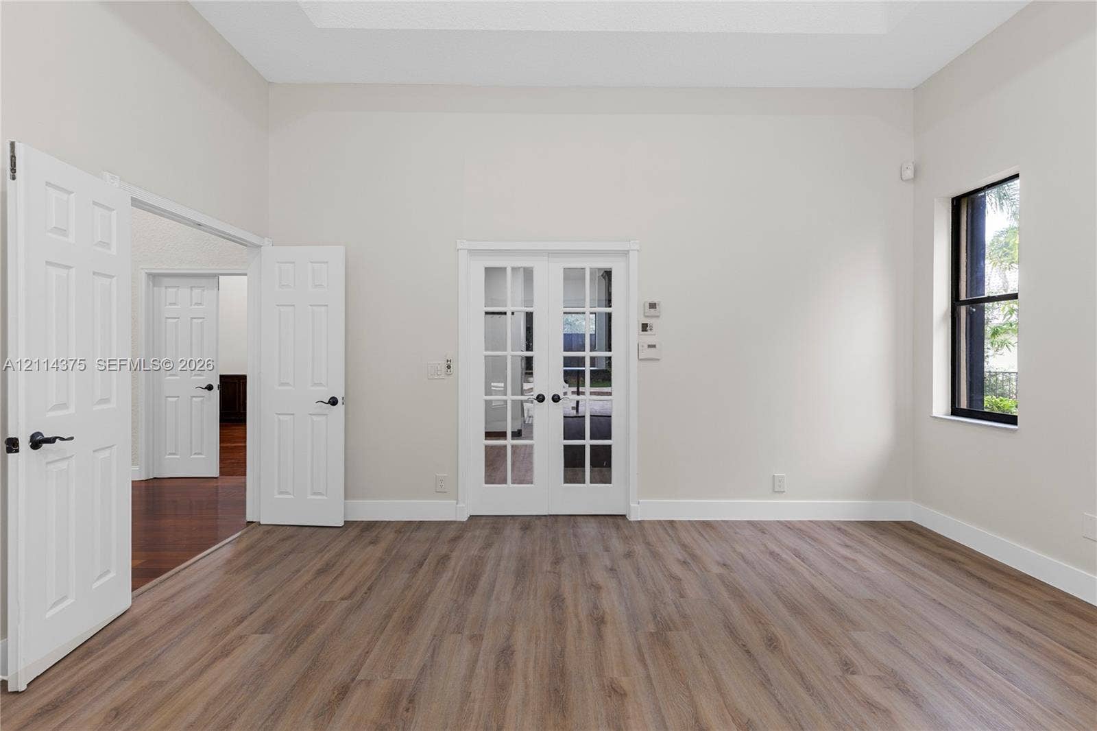 1206 S Manor Drive S, Weston, Weston, FL 33326 Room featuring high ceilings, wood-finish flooring, glass-paneled French doors, and a multi-pane window