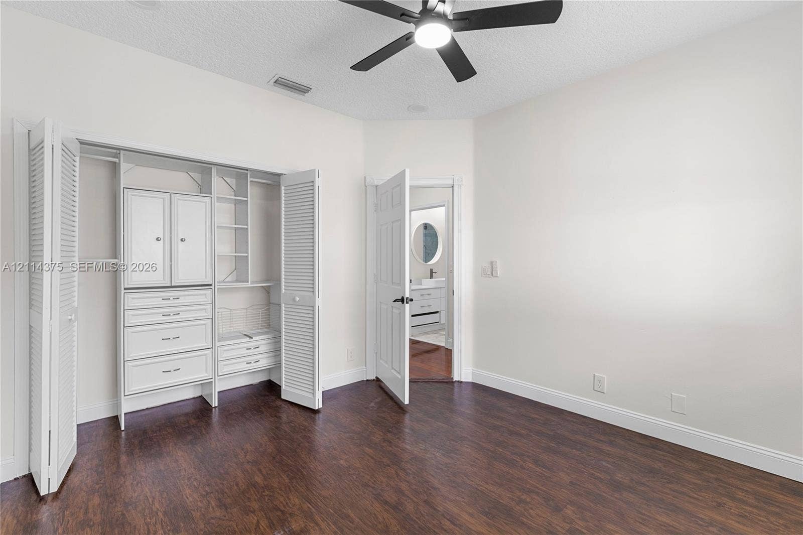 1206 S Manor Drive S, Weston, Weston, FL 33326 Wood-finish flooring, custom built-in closet cabinetry with drawers and shelving, and a matte black ceiling fan