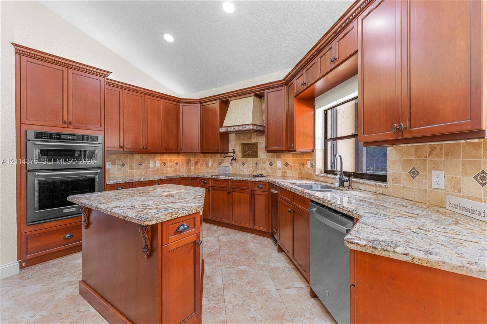 1206 S Manor Drive S, Weston, Weston, FL 33326 Kitchen featuring wood cabinetry, stone countertops, tiled backsplash, built-in double wall oven, and a center island