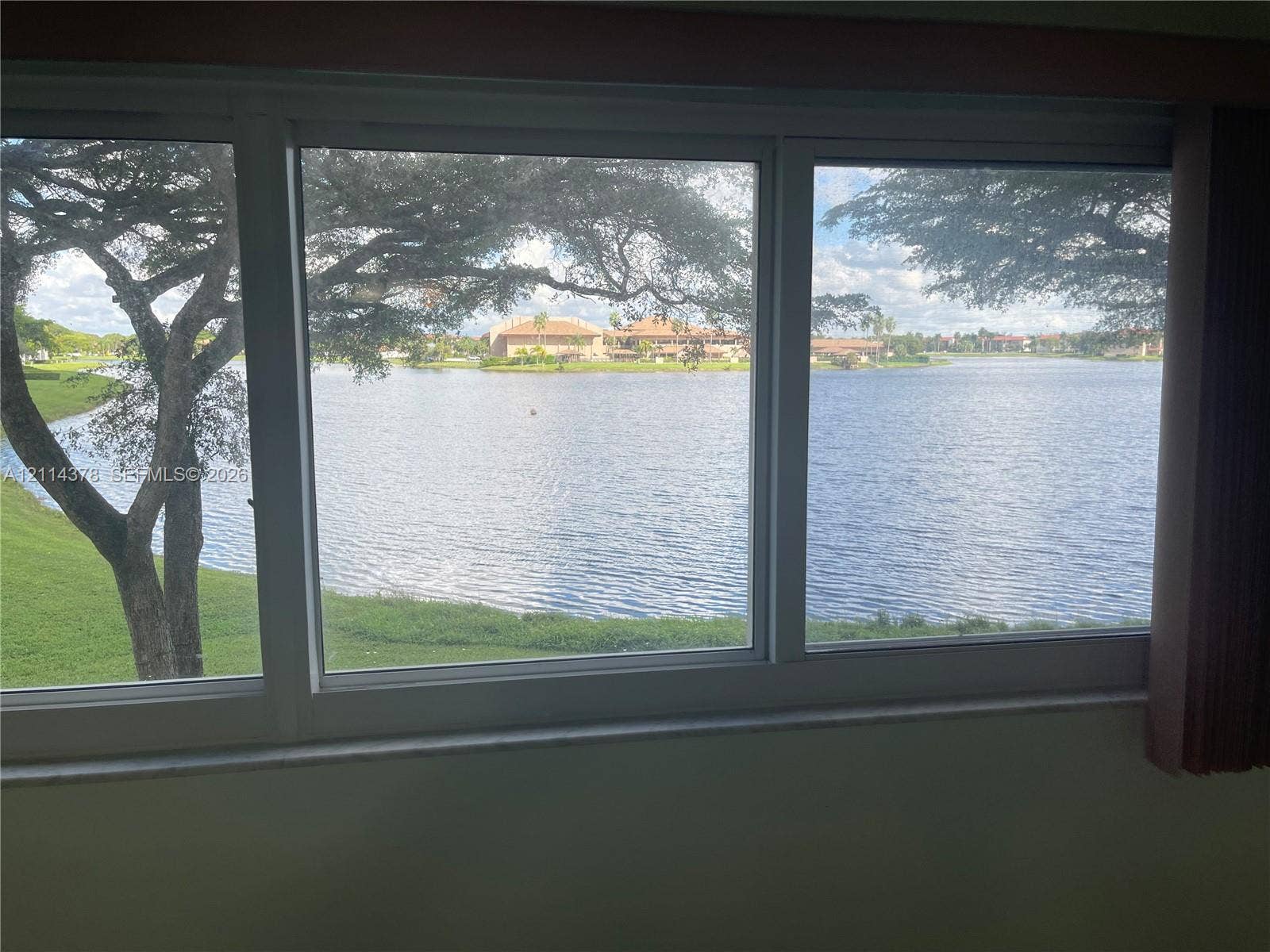 13355 SW 16th Court, #205E, Pembroke Pines, FL 33027 Large multi-pane window featuring white frames, a stone sill, and expansive water frontage