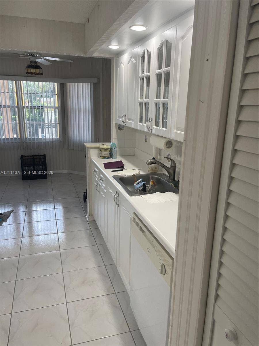 13355 SW 16th Court, #205E, Pembroke Pines, FL 33027 Kitchen featuring white cabinetry with glass-panel upper doors, recessed lighting, tile flooring, and integrated dishwasher