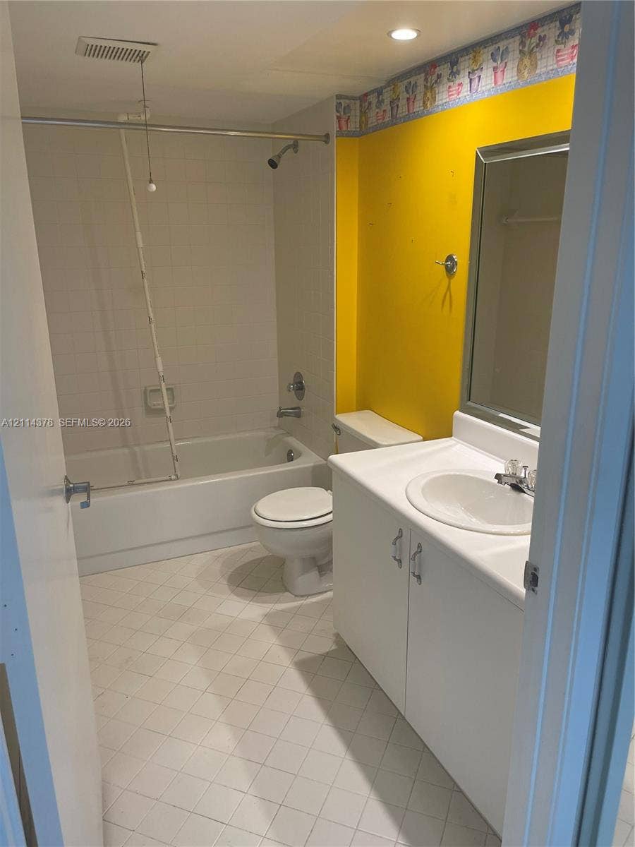 13355 SW 16th Court, #205E, Pembroke Pines, FL 33027 White vanity cabinet with integrated sink, porcelain tub and shower combination, and tiled flooring