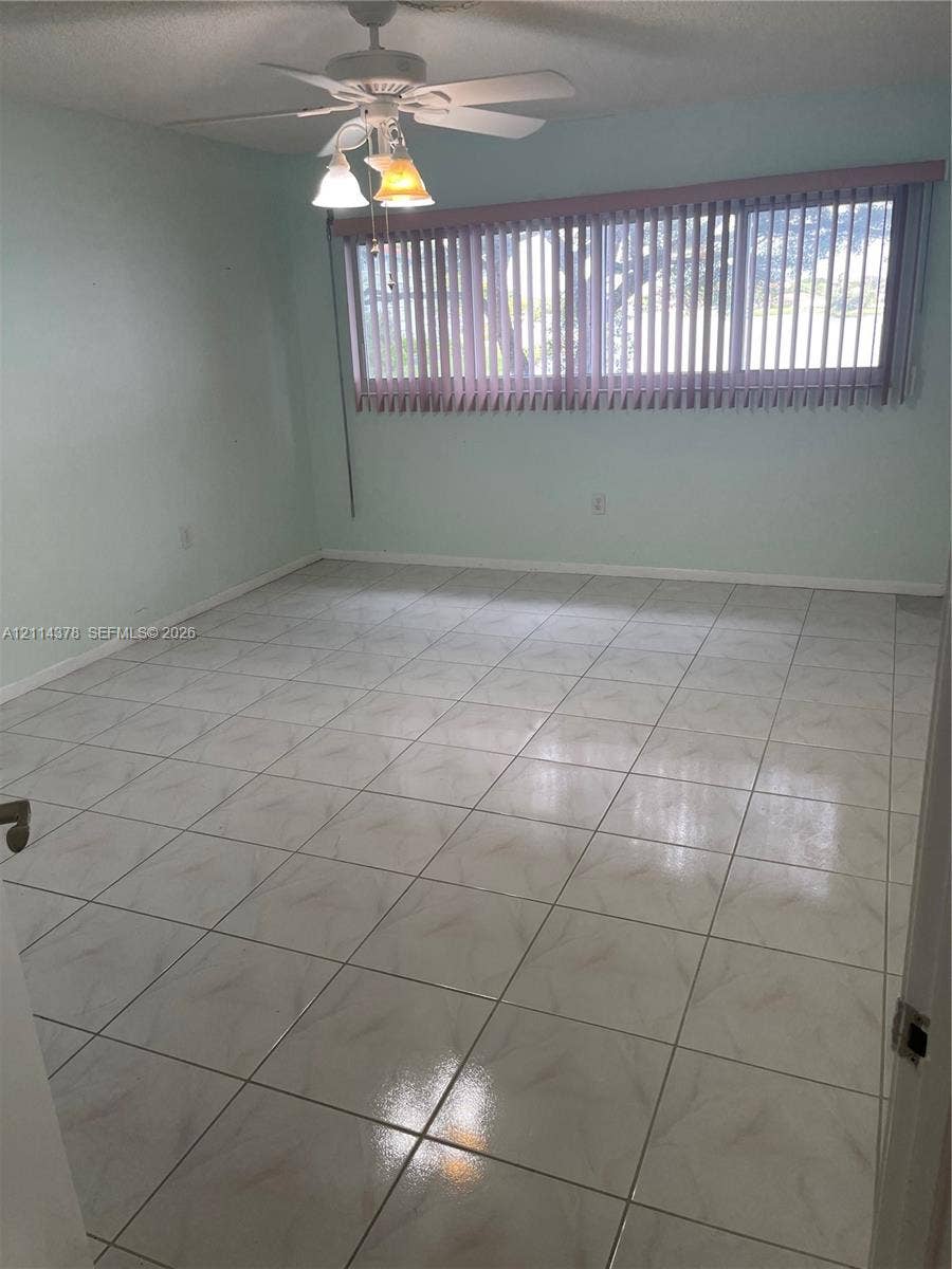 13355 SW 16th Court, #205E, Pembroke Pines, FL 33027 Ceramic tile flooring, multi-light ceiling fan, and large horizontal window with vertical blinds