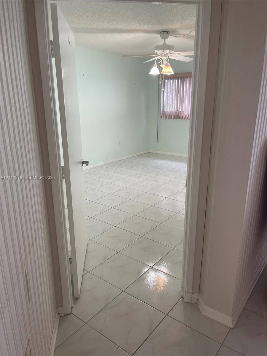 13355 SW 16th Court, #205E, Pembroke Pines, FL 33027 Interior space featuring polished ceramic tile flooring, a multi-blade ceiling fan with integrated light fixture, and vertical window blinds