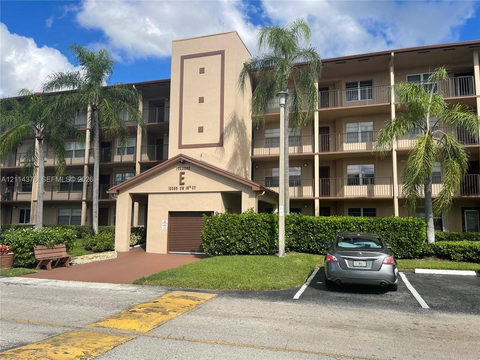 13355 SW 16th Court, #205E, Pembroke Pines, FL 33027 Multi-story stucco exterior featuring private balconies and mature palm tree landscaping