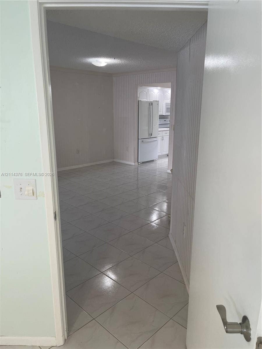 13355 SW 16th Court, #205E, Pembroke Pines, FL 33027 Ceramic tile flooring, white wainscoting wall paneling, and flush-mount lighting fixtures