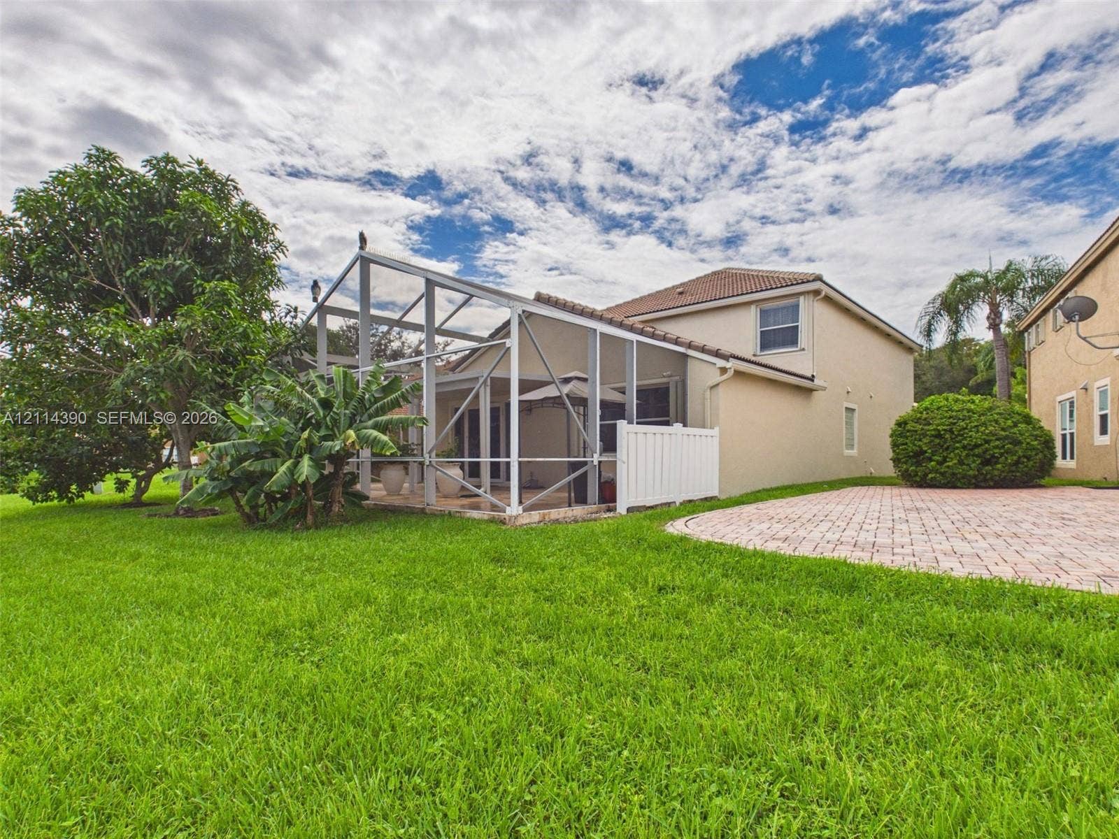 21196 Via Ventura, Boca Raton, FL 33433 Screened-in lanai featuring a concrete patio, exterior stucco finish, tiled roof, and paver hardscaping