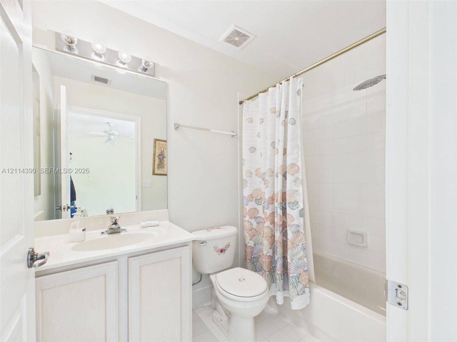 21196 Via Ventura, Boca Raton, FL 33433 Bathroom featuring a white vanity cabinet with an integrated sink, full-width vanity mirror, polished chrome lighting fixture, and a tub-shower combination with white wall tile