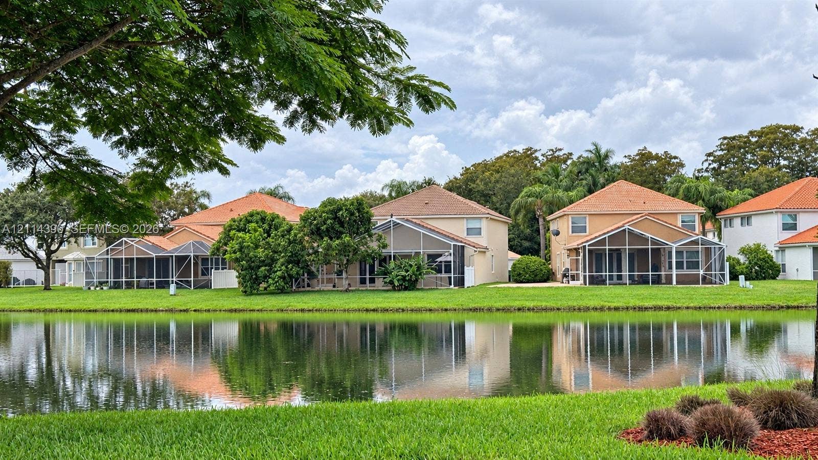 21196 Via Ventura, Boca Raton, FL 33433 Waterfront property featuring screened-in lanais, tile roofs, and manicured landscaping