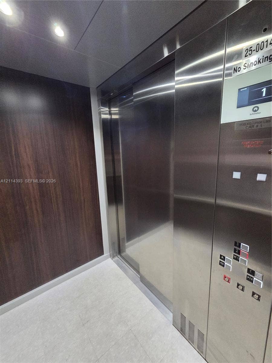 401 Pembroke Road, #202, Hallandale Beach, Hallandale Beach, FL 33009 Elevator cab featuring stainless steel doors and control panel, wood-finish wall paneling, and recessed ceiling lighting