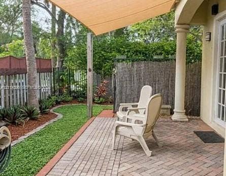 Fort Lauderdale, FL 33315 Covered brick paver patio featuring a fabric shade sail and a classic architectural column