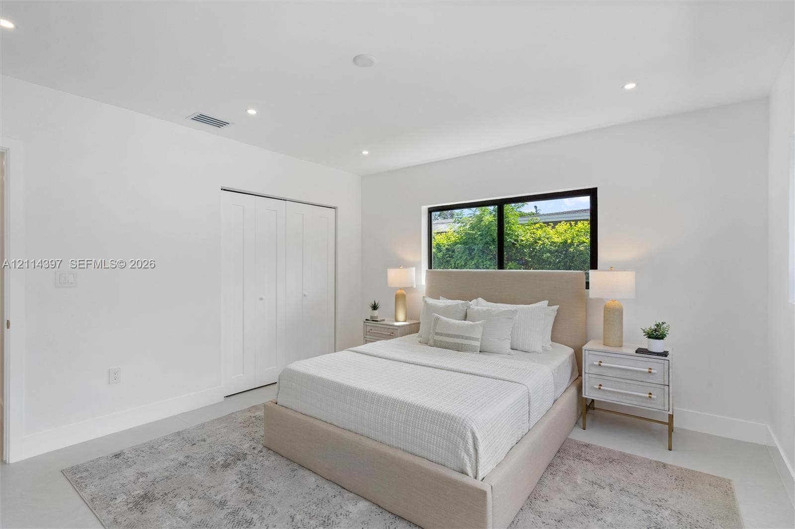 14421 SW 85th Avenue, Palmetto Bay, FL 33158 Bright interior space featuring neutral walls, recessed lighting, polished flooring, a large window with black framing, and a double-door reach-in closet