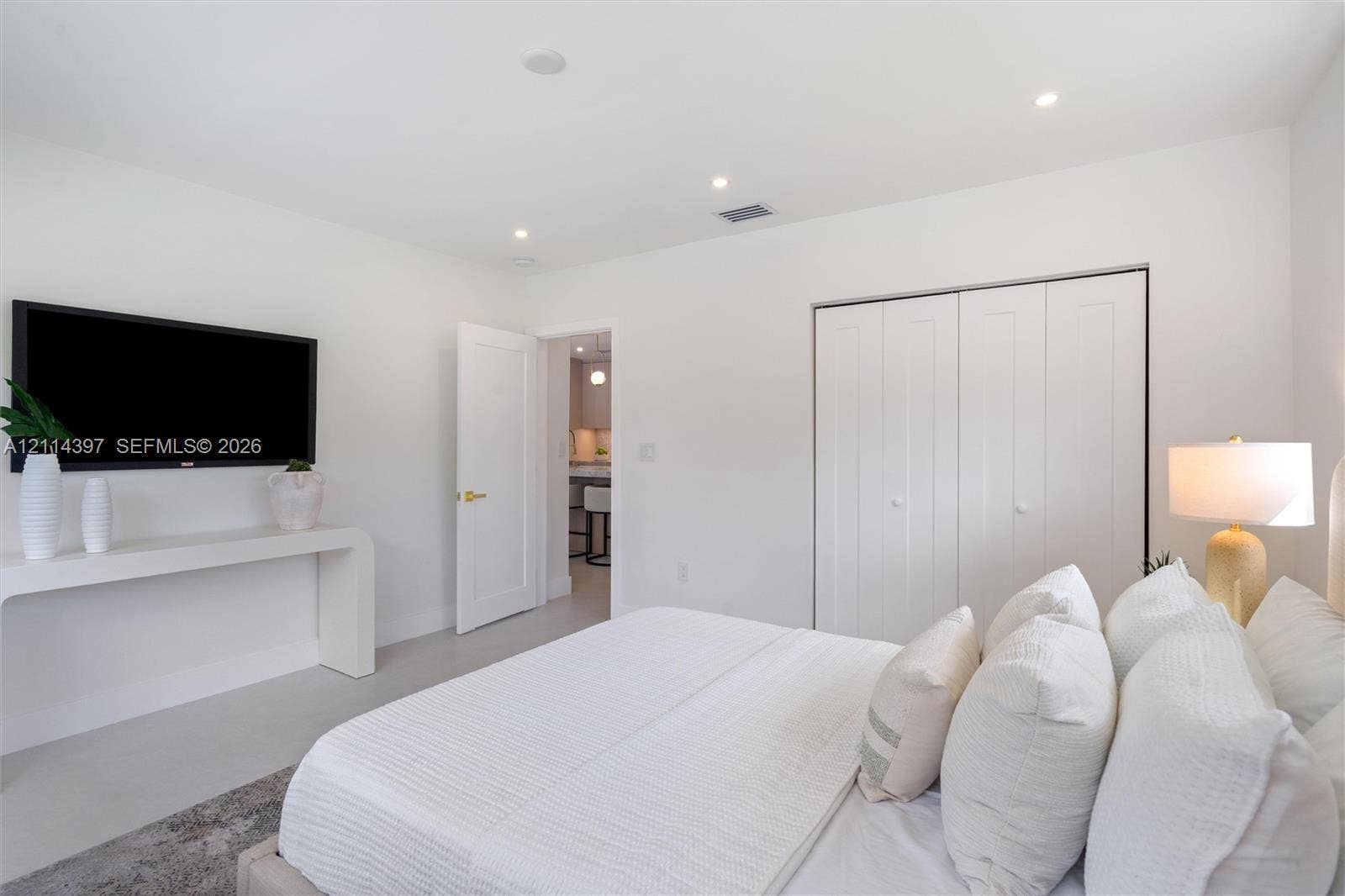 14421 SW 85th Avenue, Palmetto Bay, FL 33158 Room featuring crisp neutral walls, recessed lighting, a built-in wall-mounted console, and a closet with multi-panel doors