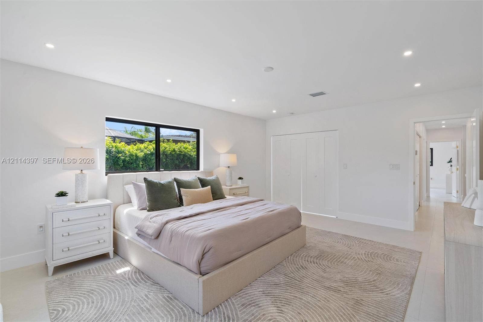 14421 SW 85th Avenue, Palmetto Bay, FL 33158 Neutral-toned room featuring recessed lighting, a large window with black framing, and multi-panel interior closet doors