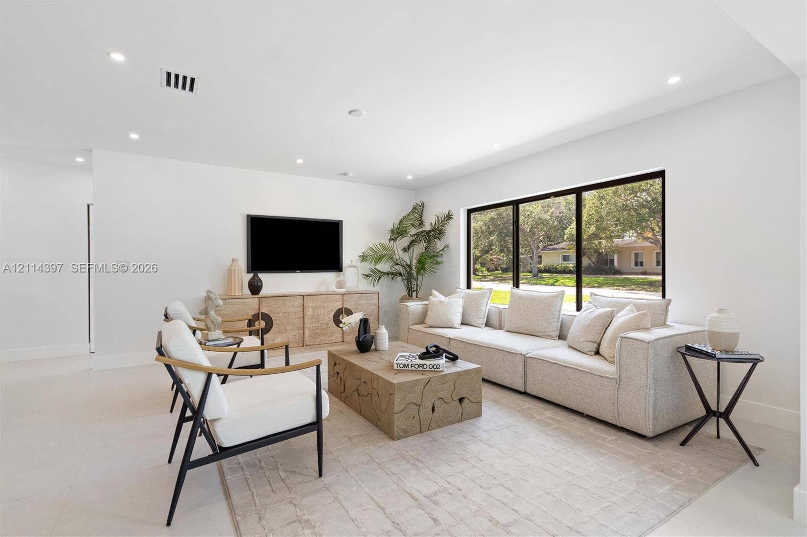 14421 SW 85th Avenue, Palmetto Bay, FL 33158 Living area featuring recessed ceiling lighting, light-toned tile flooring, and a large black-framed picture window