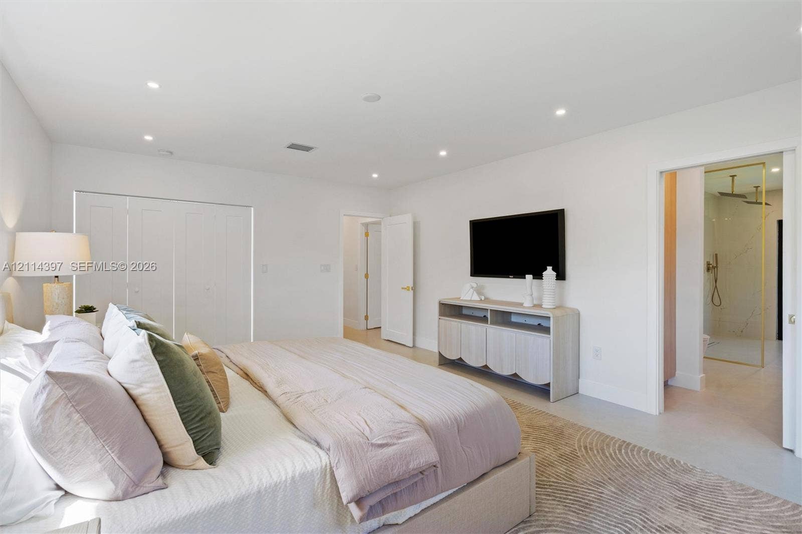 14421 SW 85th Avenue, Palmetto Bay, FL 33158 Neutral-toned interior featuring recessed ceiling lighting, a large-format tile floor, and bi-fold closet doors
