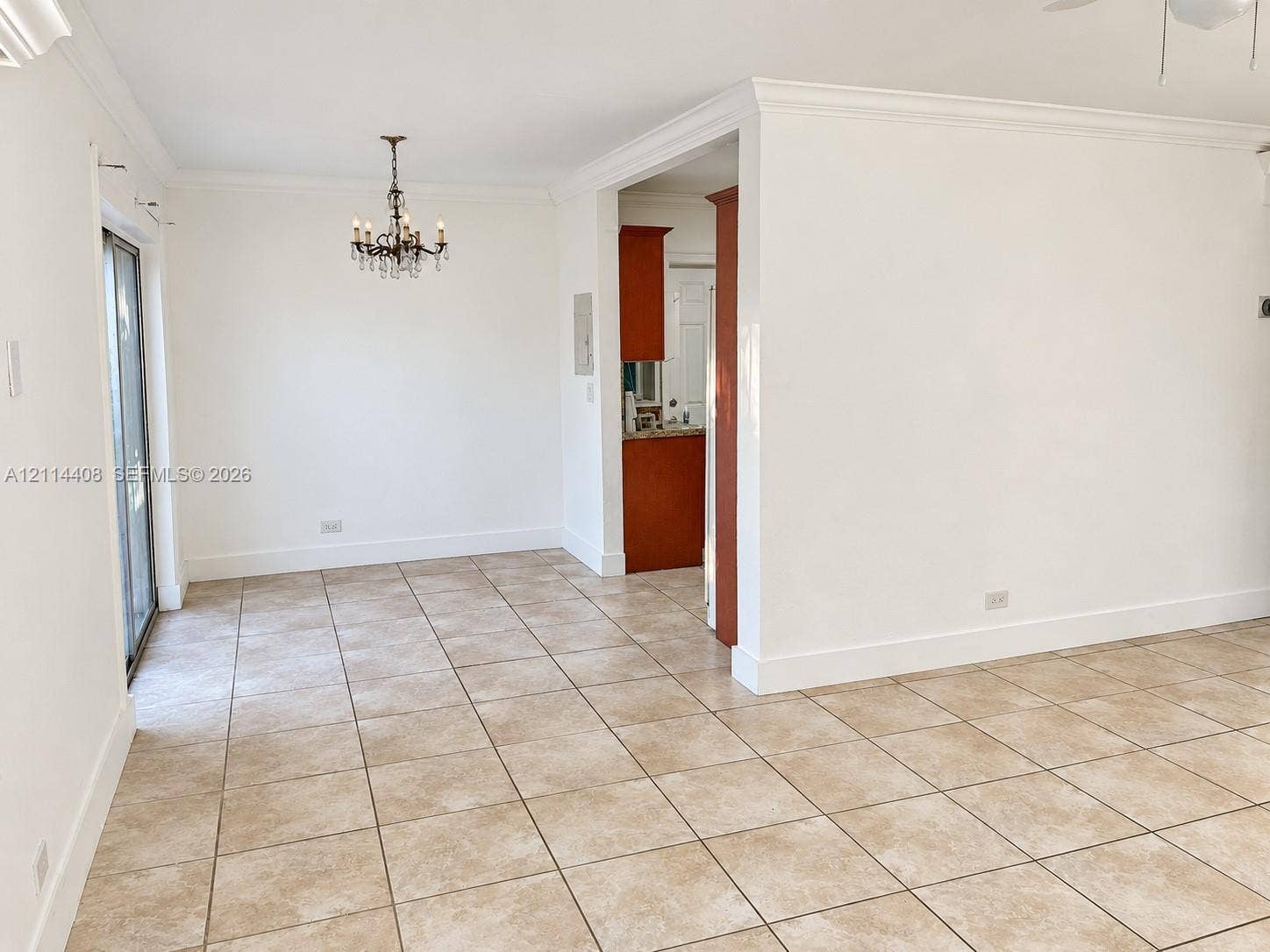 Ceramic tile flooring, crown molding, multi-arm chandelier, and sliding glass door