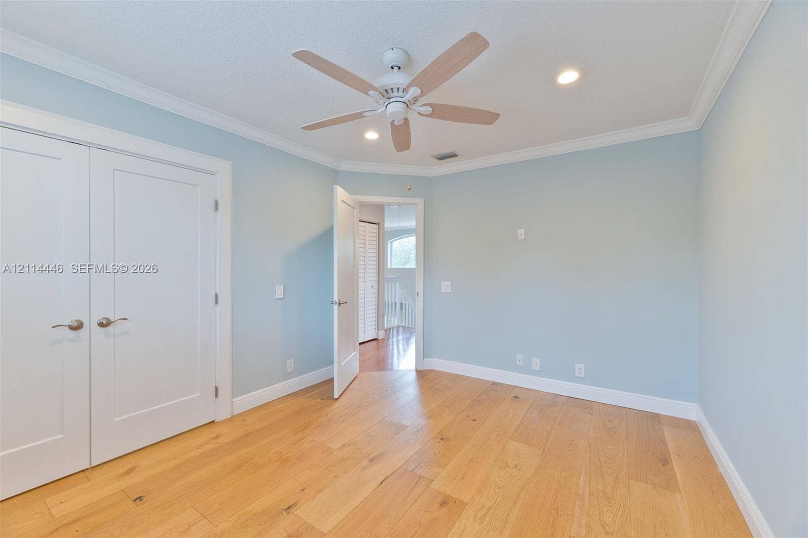 Room featuring wood-finish flooring, recessed lighting, and a multi-blade ceiling fan
