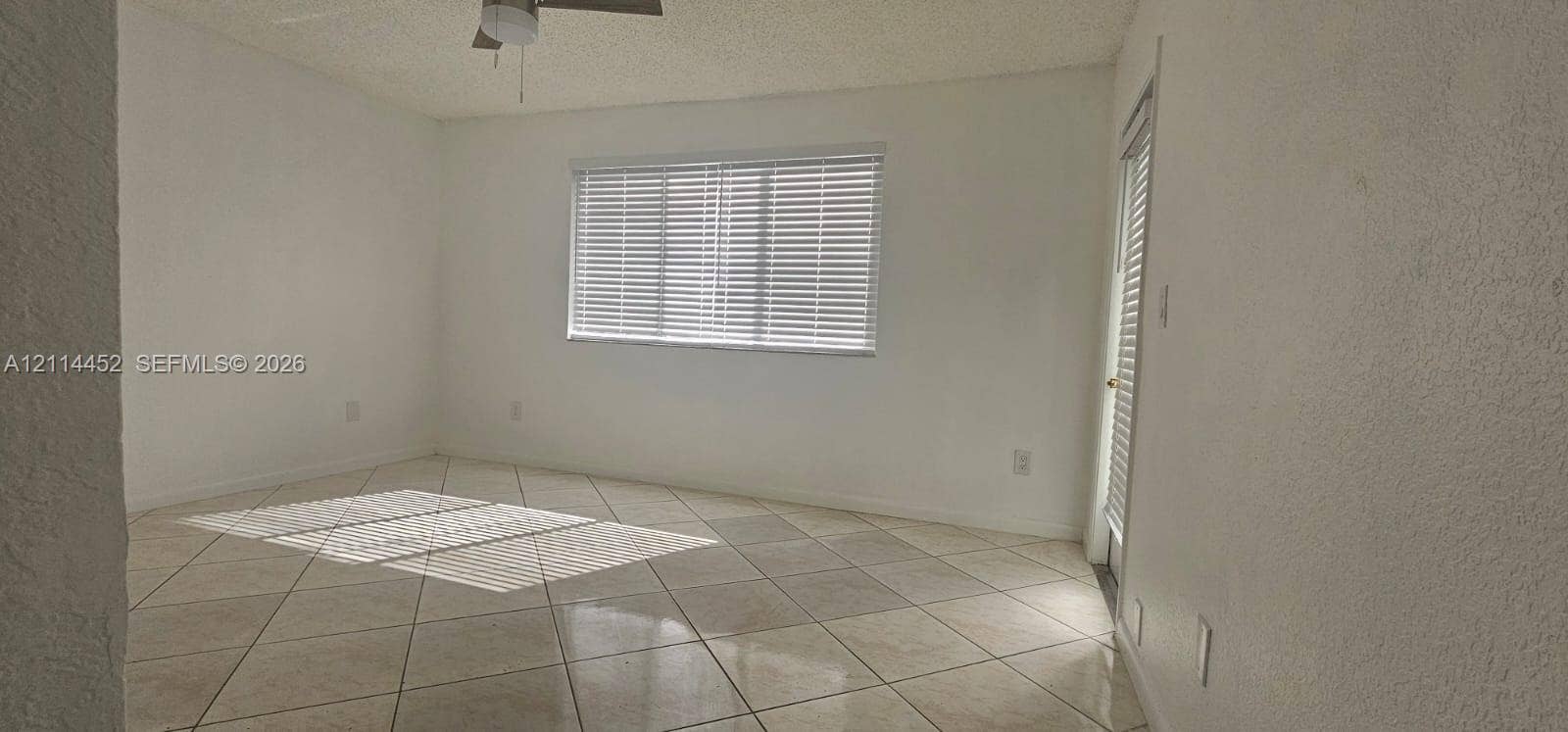 9044 W Atlantic Boulevard, #314, Coral Springs, Coral Springs, FL 33071 Room interior featuring large-format diagonal tile flooring, textured wall finish, and an integrated ceiling fan