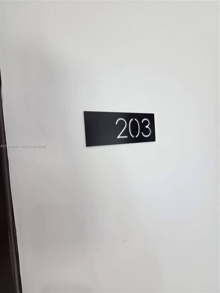 401 Pembroke Road, #203, Hallandale Beach, Hallandale Beach, FL 33009 Minimalist black rectangular signage featuring high-contrast white numerals