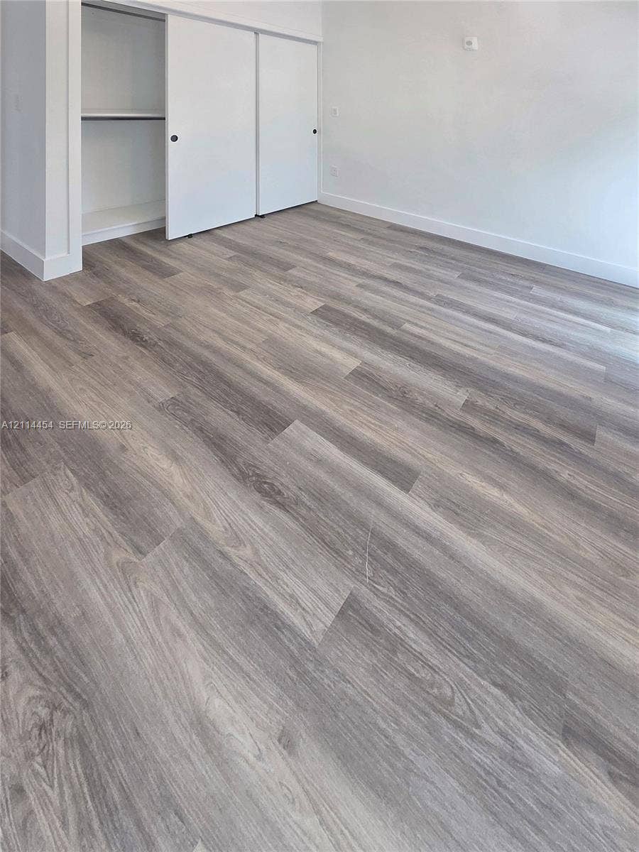401 Pembroke Road, #203, Hallandale Beach, Hallandale Beach, FL 33009 Wood-finish flooring, neutral wall tones, and a built-in closet with sliding doors