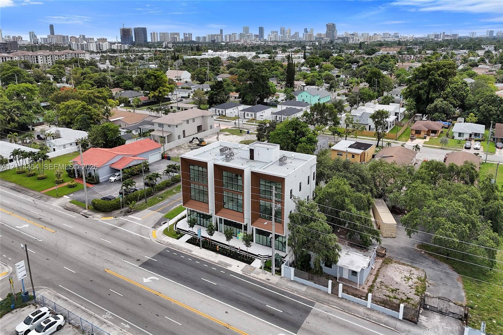 401 Pembroke Road, #203, Hallandale Beach, Hallandale Beach, FL 33009 Contemporary three-story structure featuring a concrete facade, wood-finish paneling, expansive floor-to-ceiling windows, a flat roof, and metal balcony railings