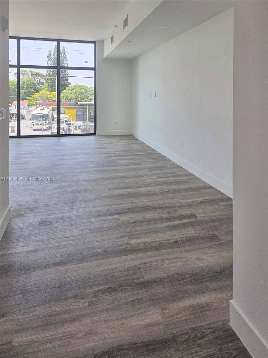 401 Pembroke Road, #203, Hallandale Beach, Hallandale Beach, FL 33009 Open-concept space featuring floor-to-ceiling windows with black metal framing and wood-finish flooring